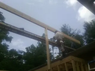 Carpenter setting a ridge beam over a new addition frame — Ice Dam Removal by Roofing Brothers in Moses Lake