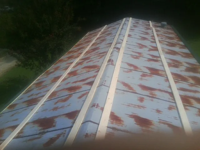 Rusted metal roof panels with new wood purlins before replacement — Storm Damage Roof Repair in Moses Lake by Roofing Brothers
