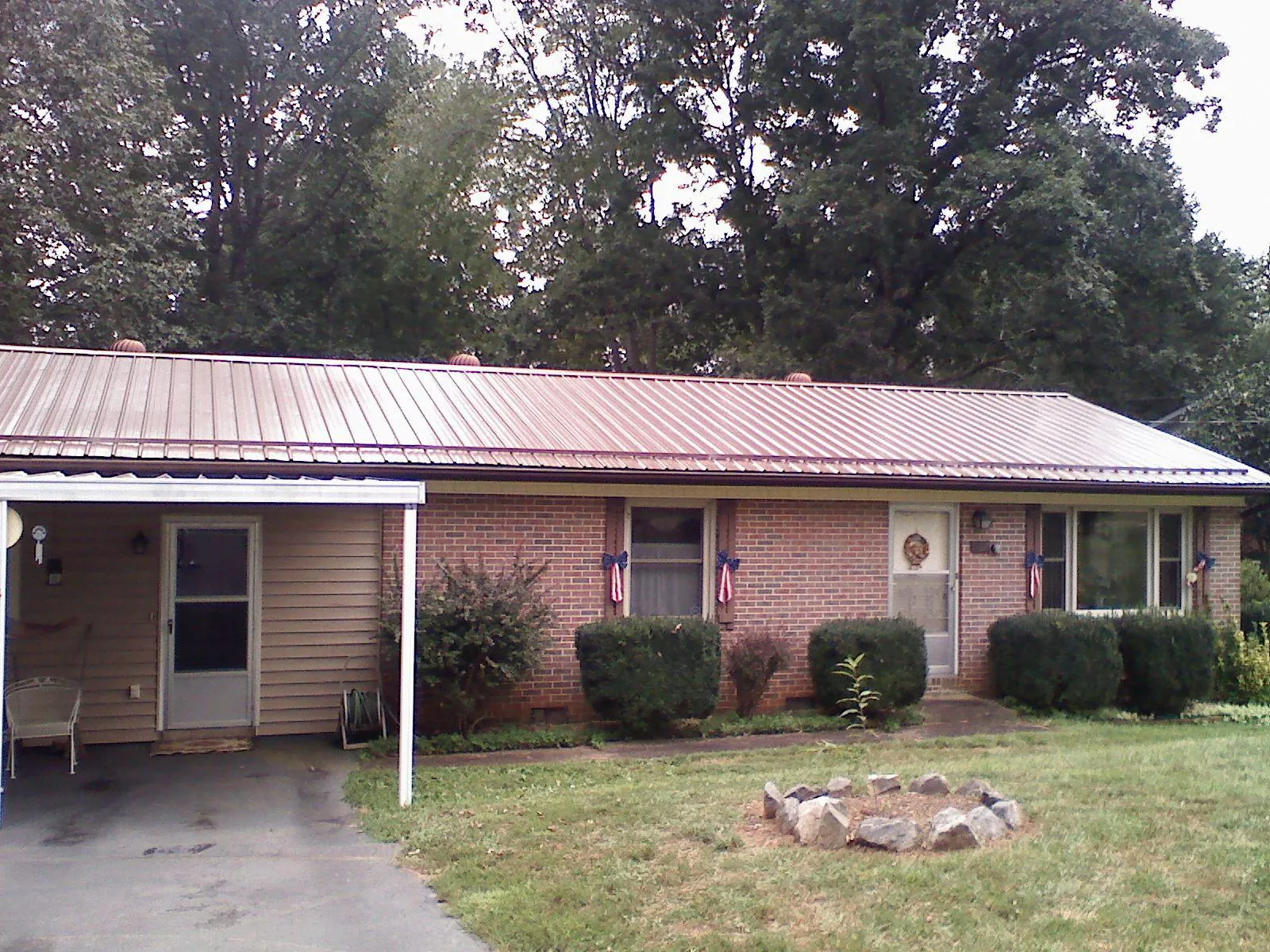 Bronze metal roof and carport on a brick ranch home — Roof Repair work by our crew in Moses Lake